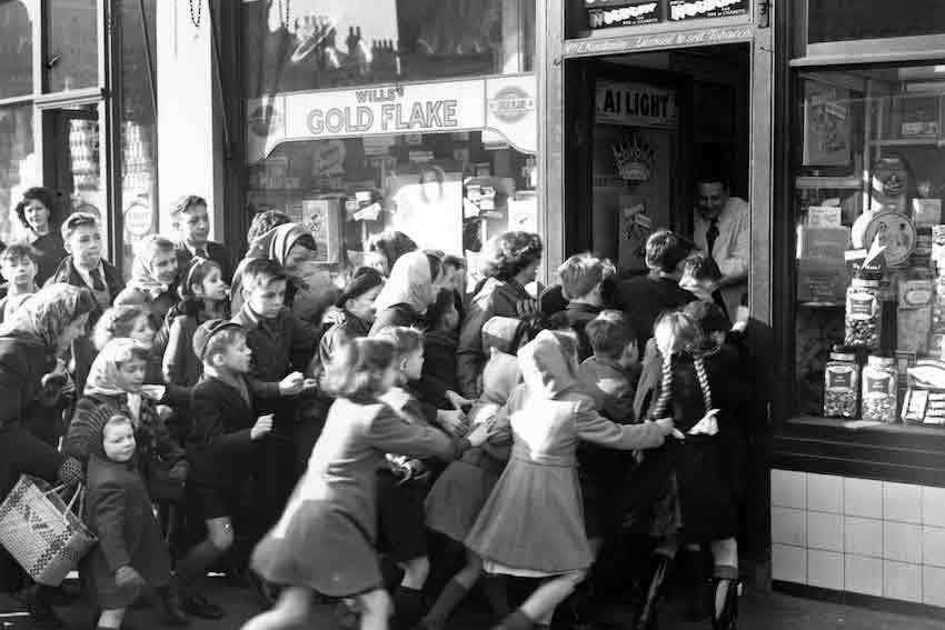 doorbusters fighting to enter a shop during Black Friday in the 50's